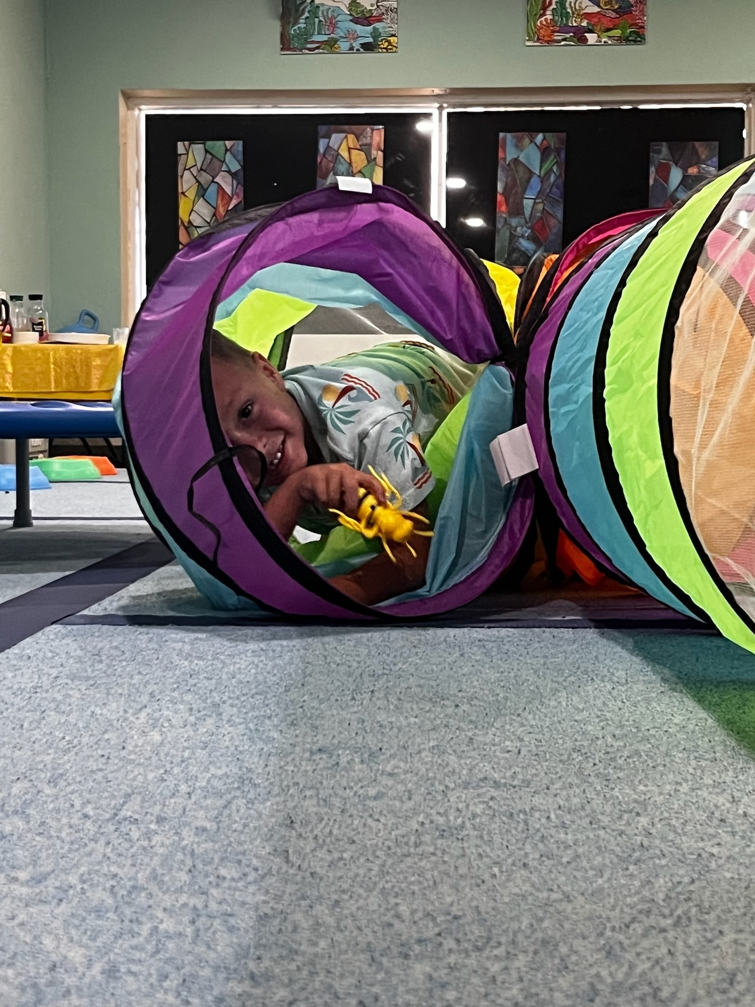 Child moving through an indoor play tunnel